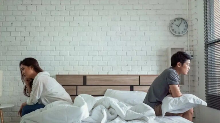 Couple sitting in the same room, emotionally distant but not arguing