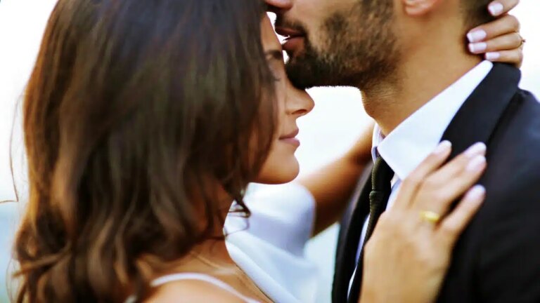 A man kissing a woman on the forehead