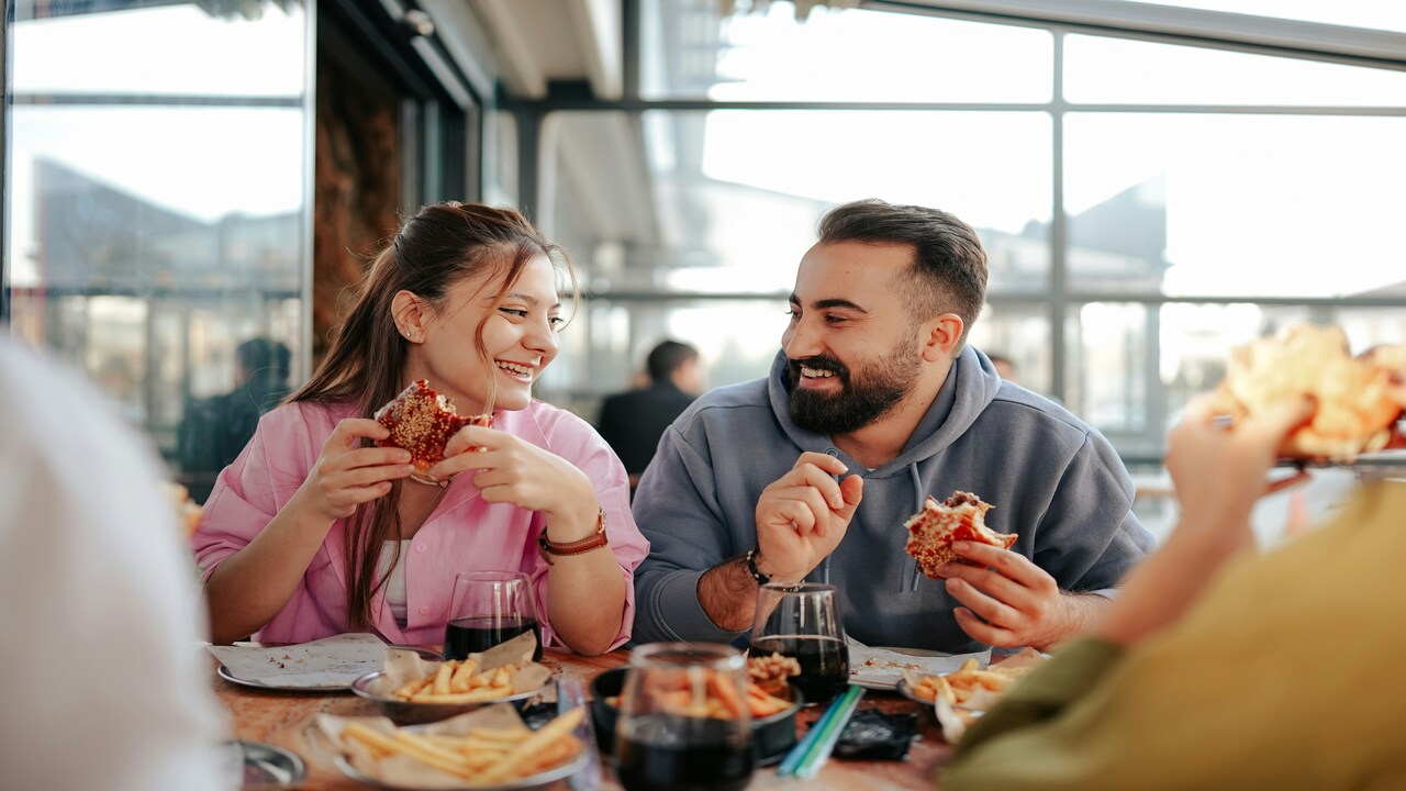 A couple laughing during a pizza date.