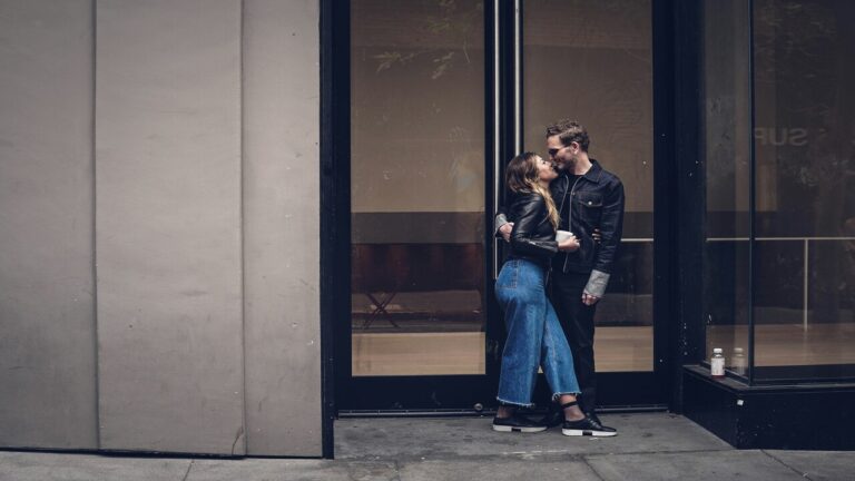 A couple kissing outdoors.