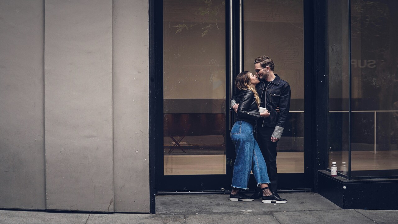 A couple kissing outdoors.